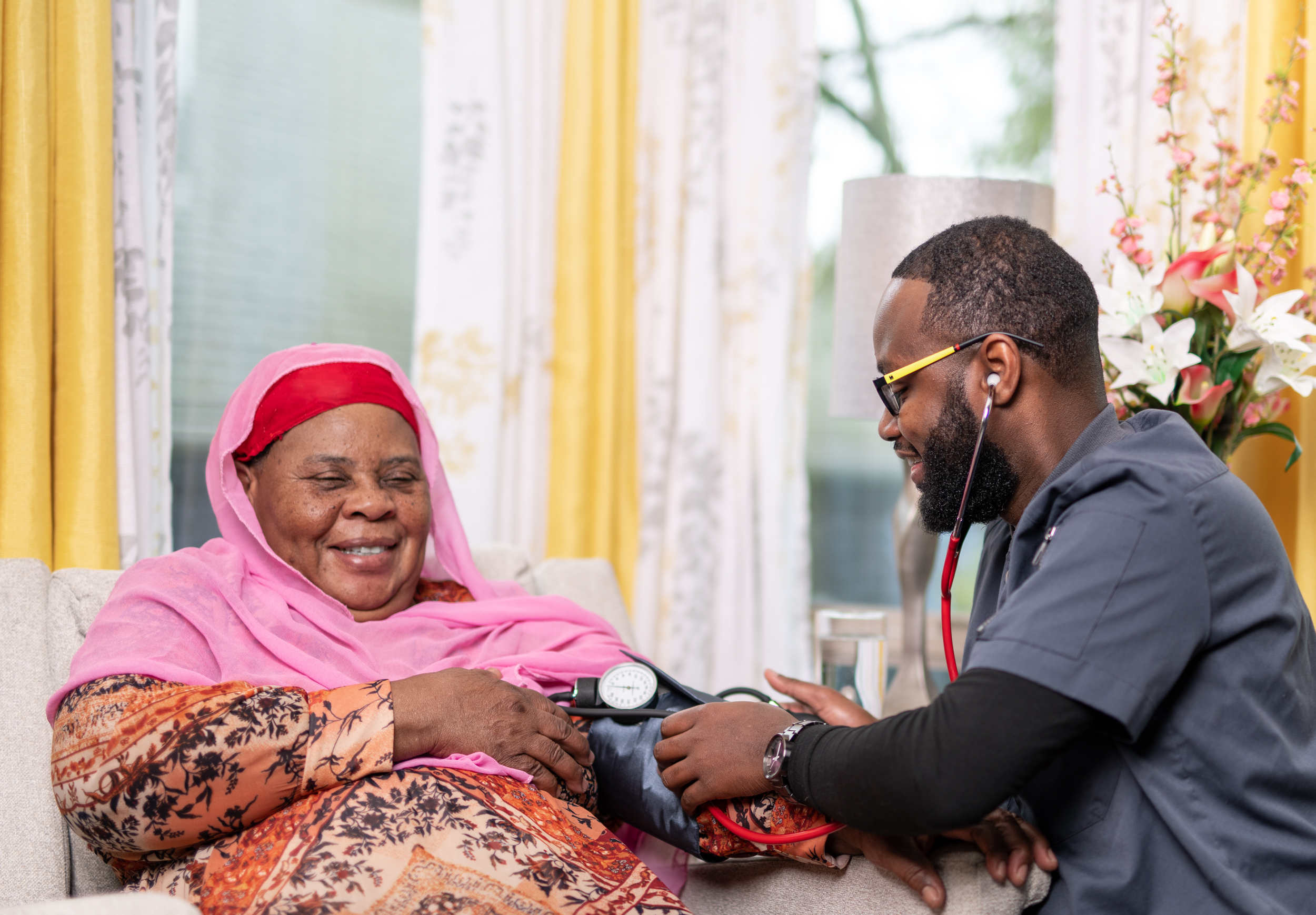 Caregiver checking blood pressure for senior woman